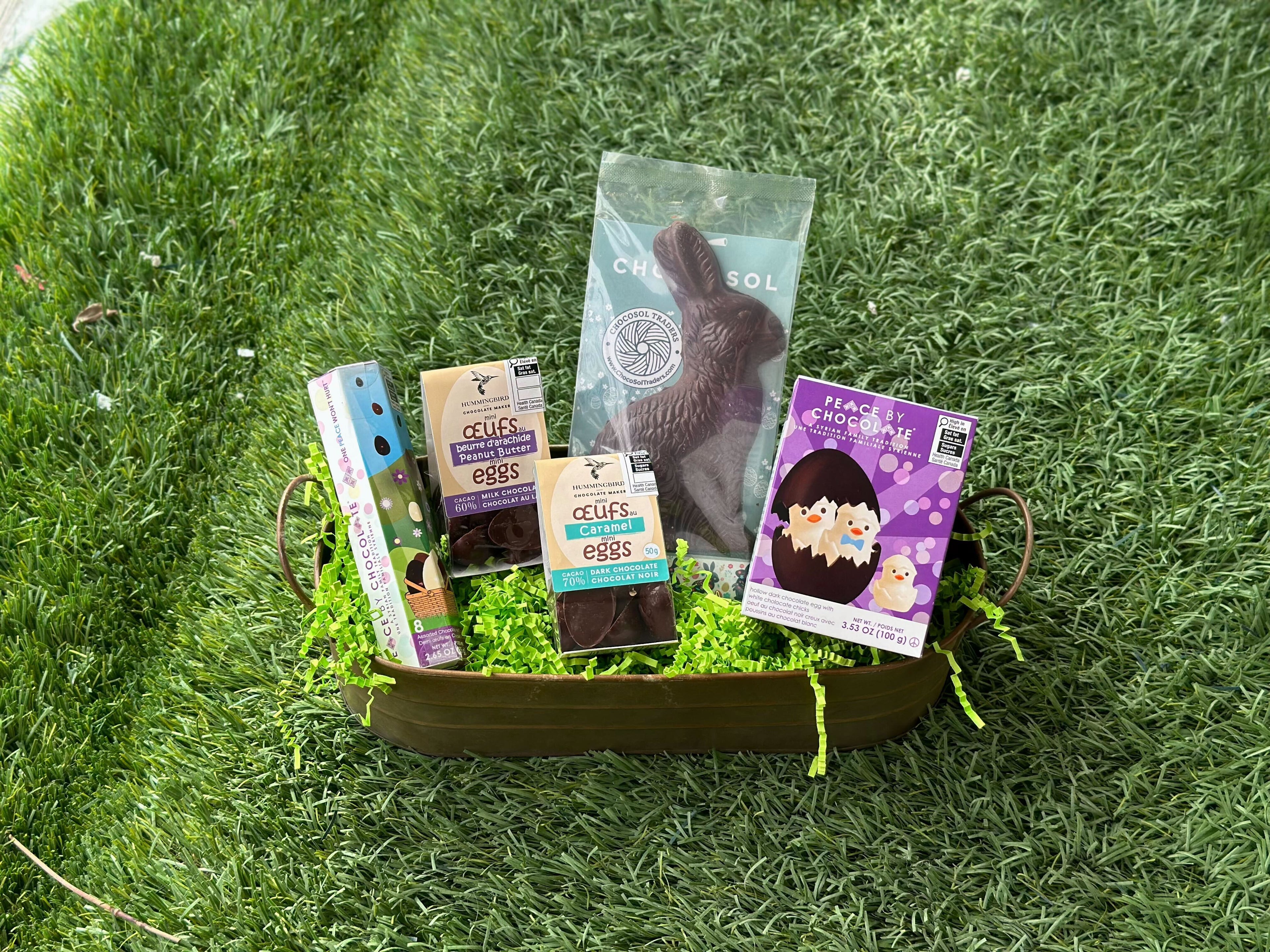 Basket with Easter products on a grassy background.