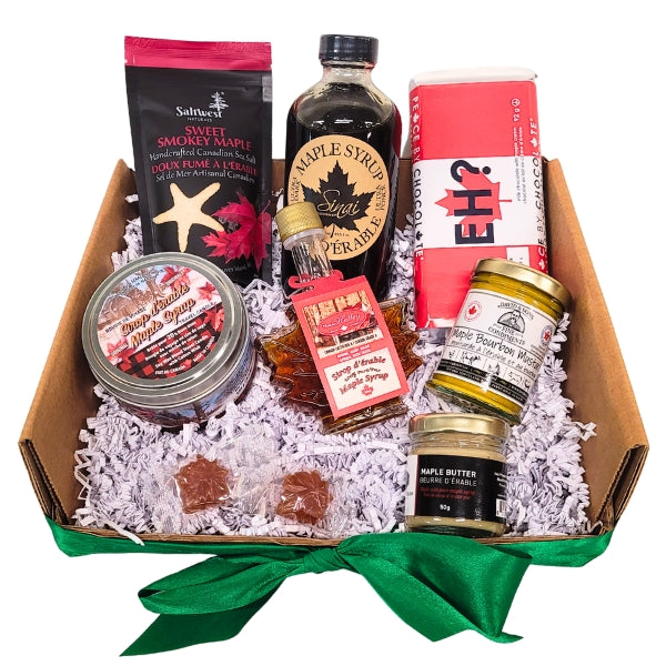 Gift basket with maple syrup products including bottles, jars, and packets on a white background.