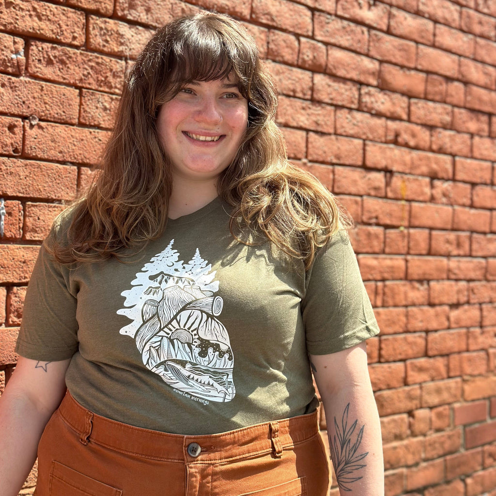 Emily wearing a green forest heart shirt.