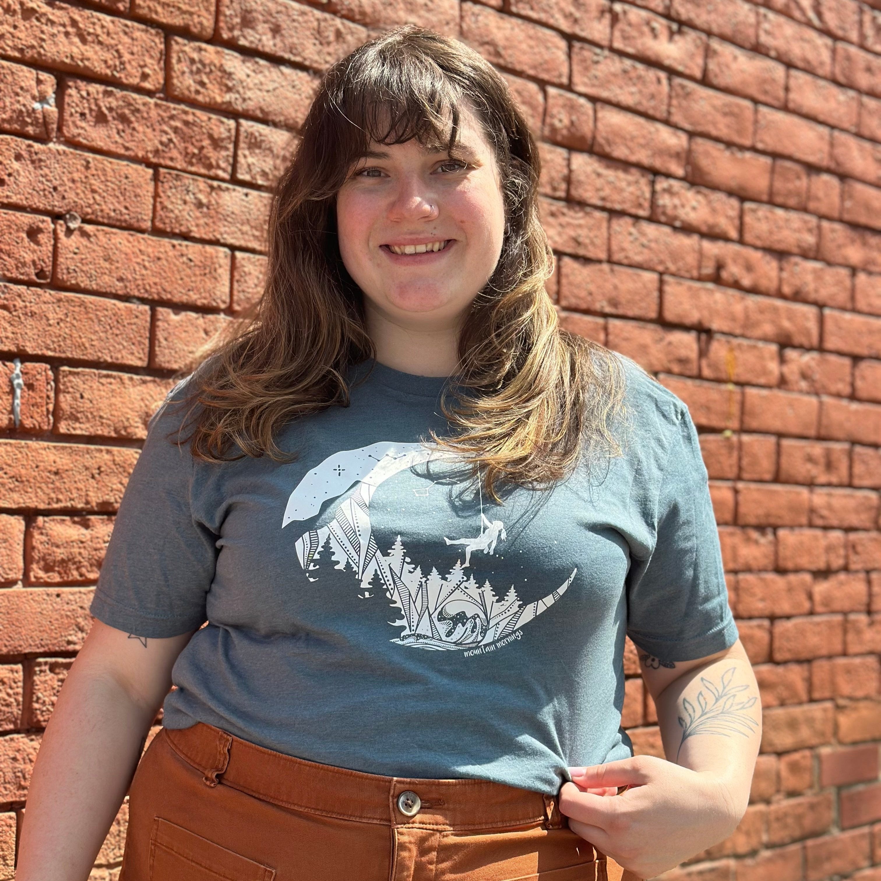 Emily wearing the Mountain Morning's moon climb shirt. 