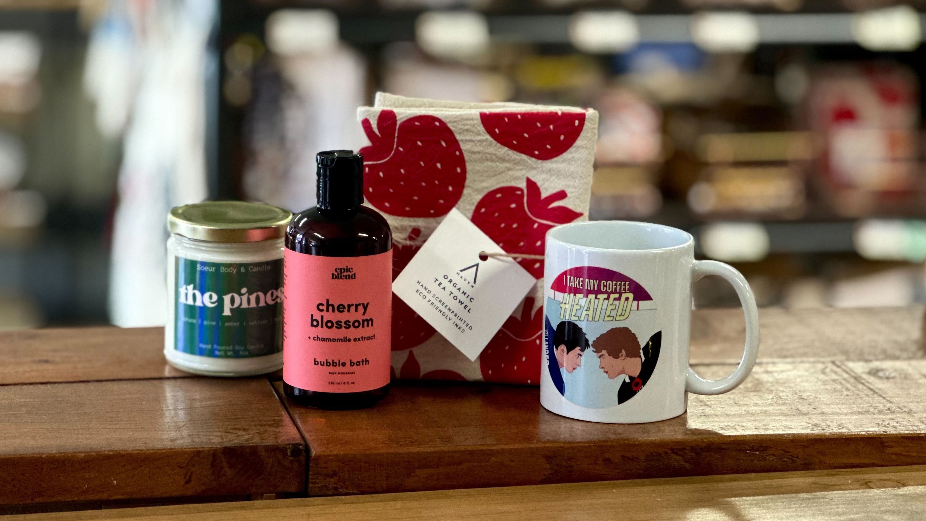 New Canadian-made products including a candle, bubble bath, a Heated Rivalry mug and an organic tea towel featuring strawberries.