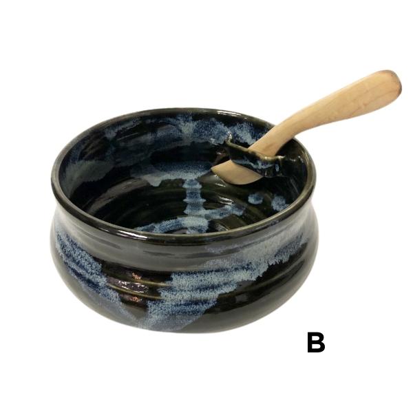 Black and blue ceramic bowl with slot on side to hold wooden knife.