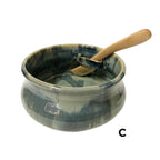 Green ceramic bowl with slot on side to hold wooden knife.