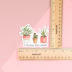 A sticker featuring artwork of a tropical plant, a cactus and a succulent (each in it's own cute pot) with the words "I fucking love plants" under them.