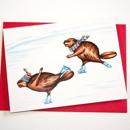 Holiday card with art by Amelie Legault.  Art shows two beavers ice skating.  One beaver is wearing a blue and red hat while the other is wearing a blue scarf.  