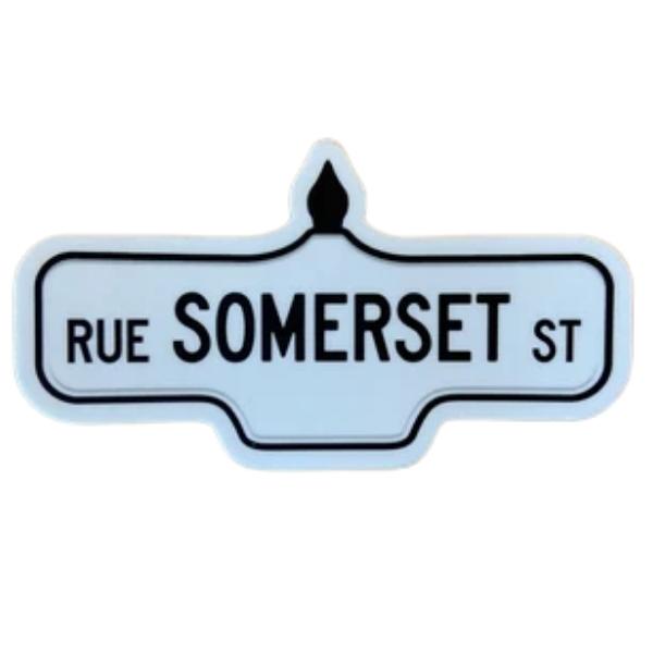 Sticker of a white street sign with black text that reads 'Rue Somerset St'.