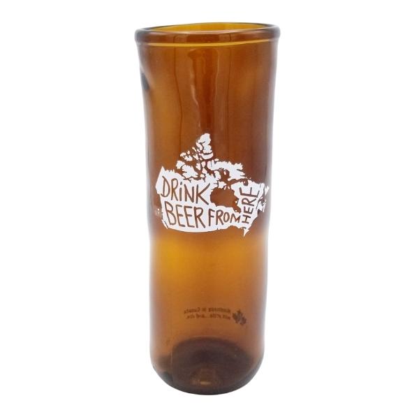 Tall brown transparent glass tumbler with a white outline image of a map of canada. Text within the map reads "Drink Beer from here".