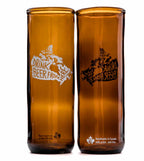 Tall brown transparent glass tumbler with a white outline image of a map of canada. Text within the map reads "Drink Beer from here". On the right is the same glass from the back. Written Handmade in Canada with pride is written on the bottom.