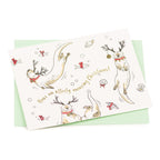 A white card with illustrated playful otters wearing reindeer antlers and red collars. Gold foil text reads "Have an otterly amazing Christmas!"